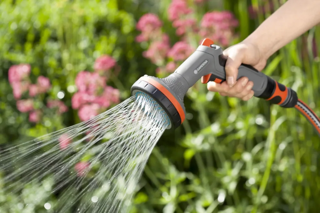 Comfort shower for flowerbeds, impulse trigger with locking function